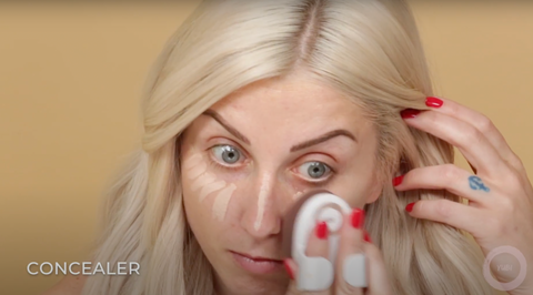 A makeup artist using a wet Yubi sponge to effortlessly blend in concealer on her face