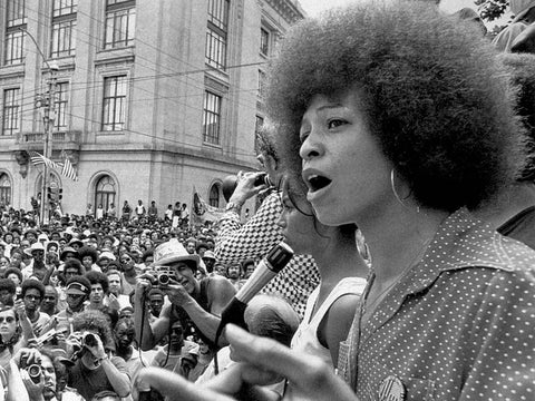 Angela Davis speaking at a Black Civil Rights Rally, sporting Black afro hair as a symbol of Black beauty