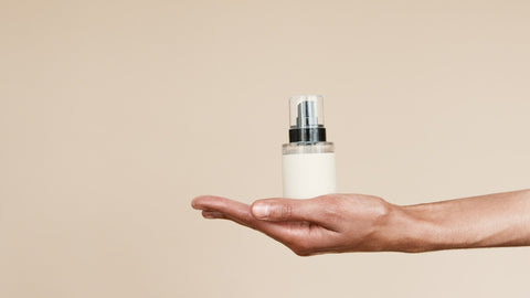 A bottle of budget-friendly beauty product on someone's hand, brandless