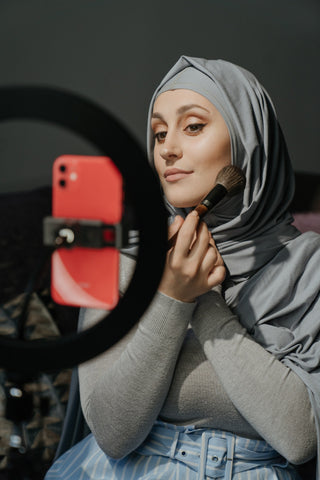 A woman applying her makeup powder for a flawless finish