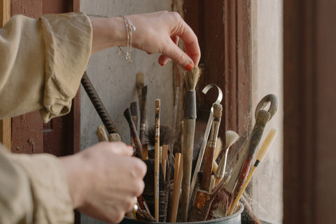 A woman tossing overly stained brushes