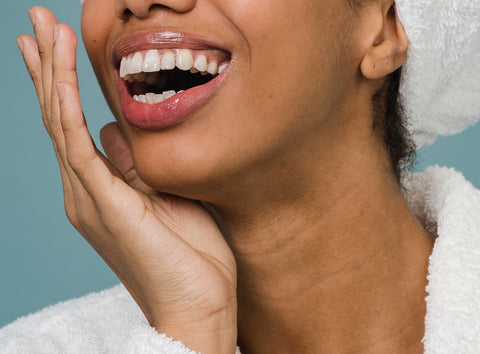 A woman identifying her smile line for blush application