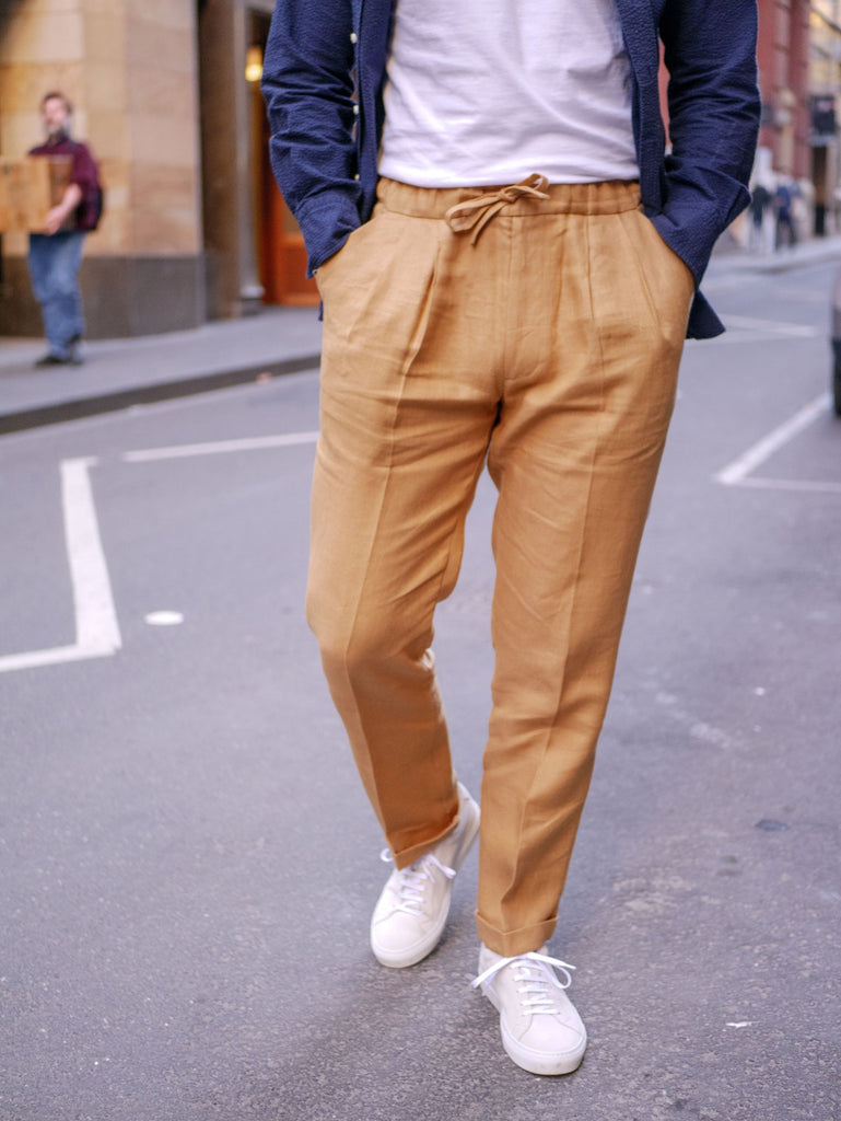 Close_Up_Of_Caramel_Irish_Linen_Drawstring_Trousers_with_Suede_Yogurt_White_Sneakers_51_Label
