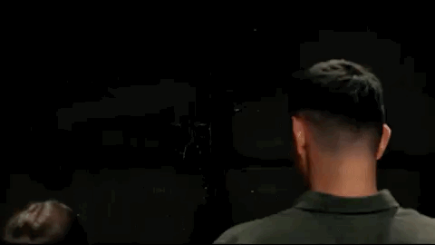 Man turning around surprised as a boxer rapidly punches a speed bag.