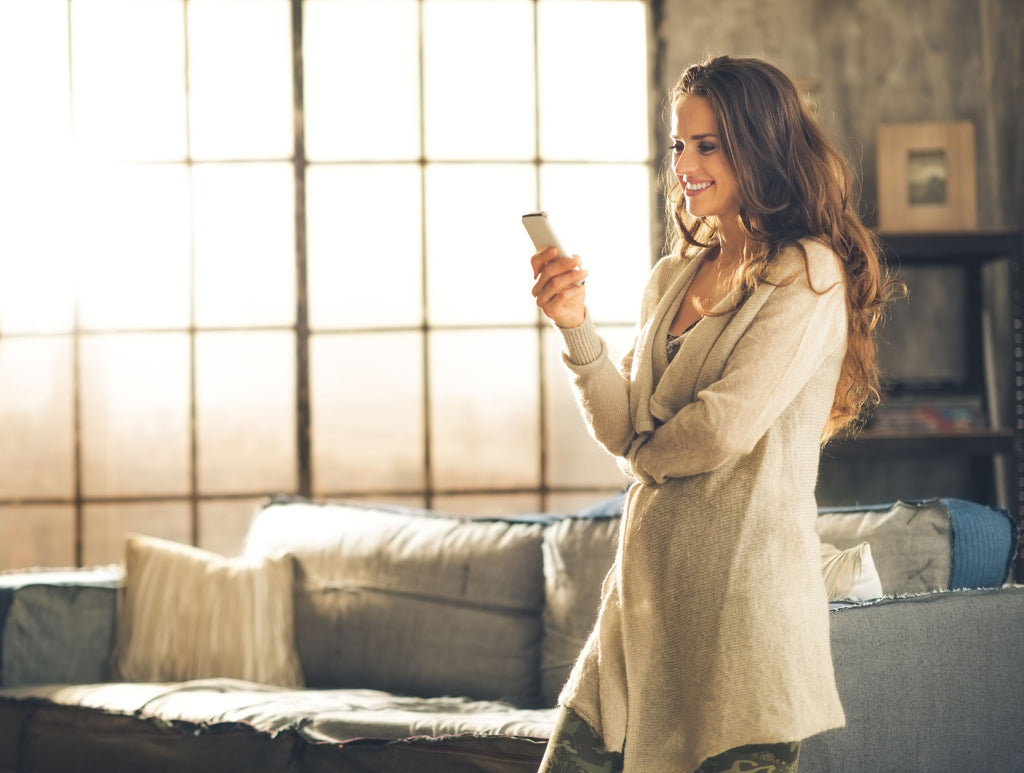 Woman controlling home with smart phone