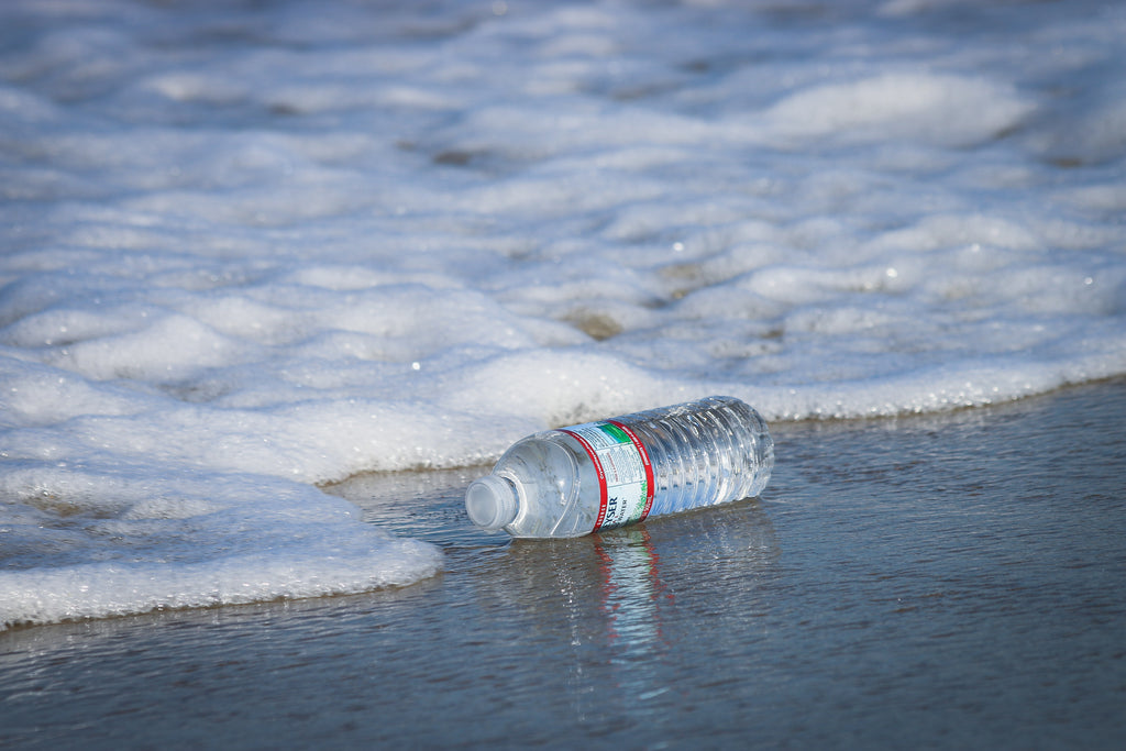A plastic water bottle on a sandy beach