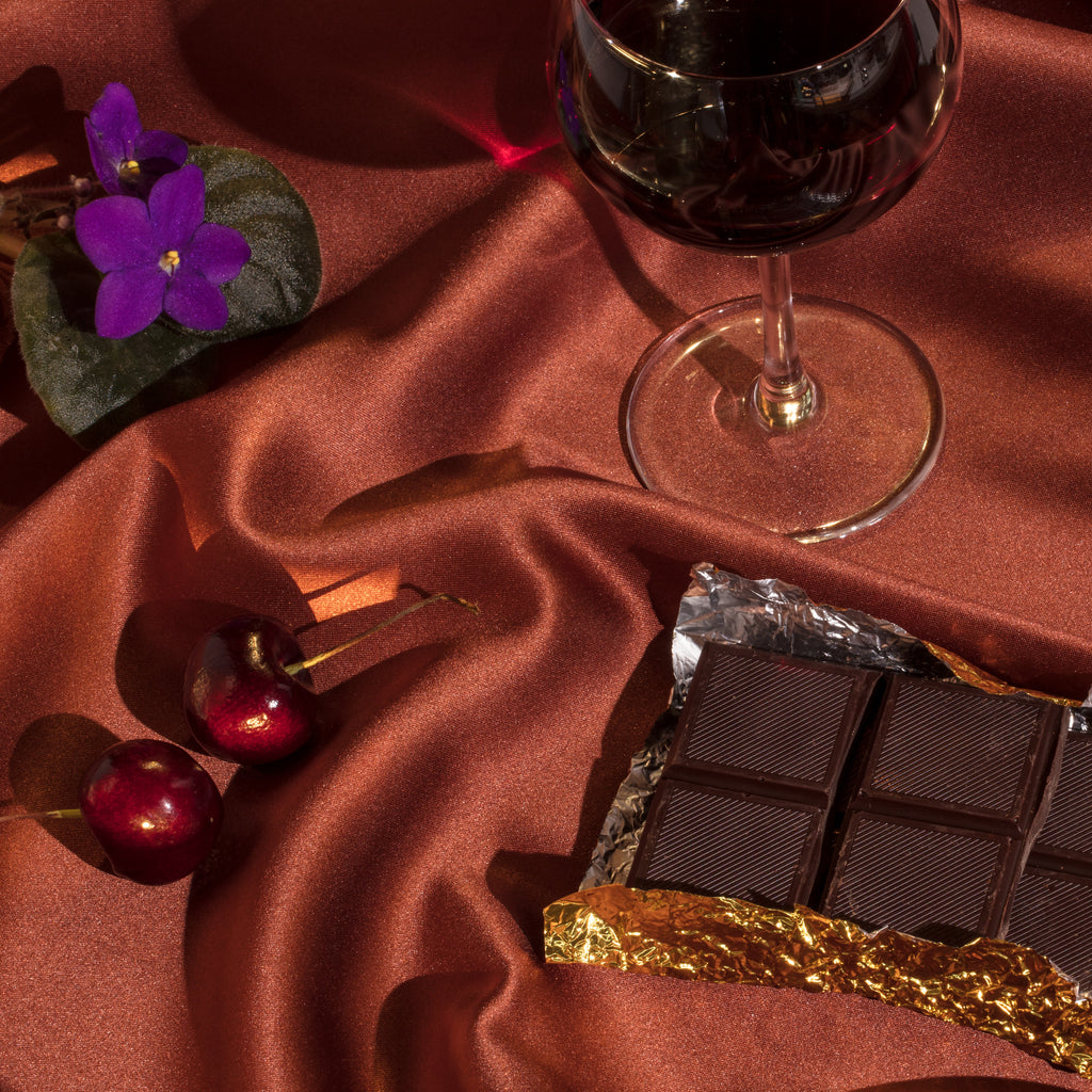 A glass of red wine with cherries and chocolate