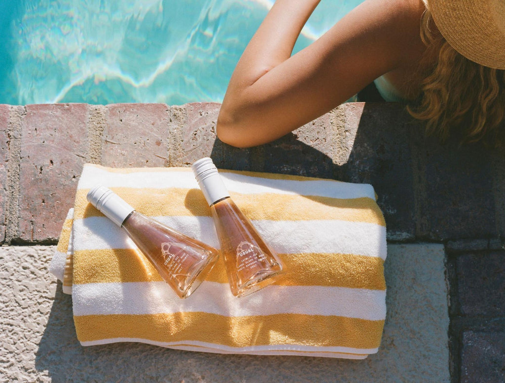 woman by the poolside with two bottles of Rosé from Usual Wines