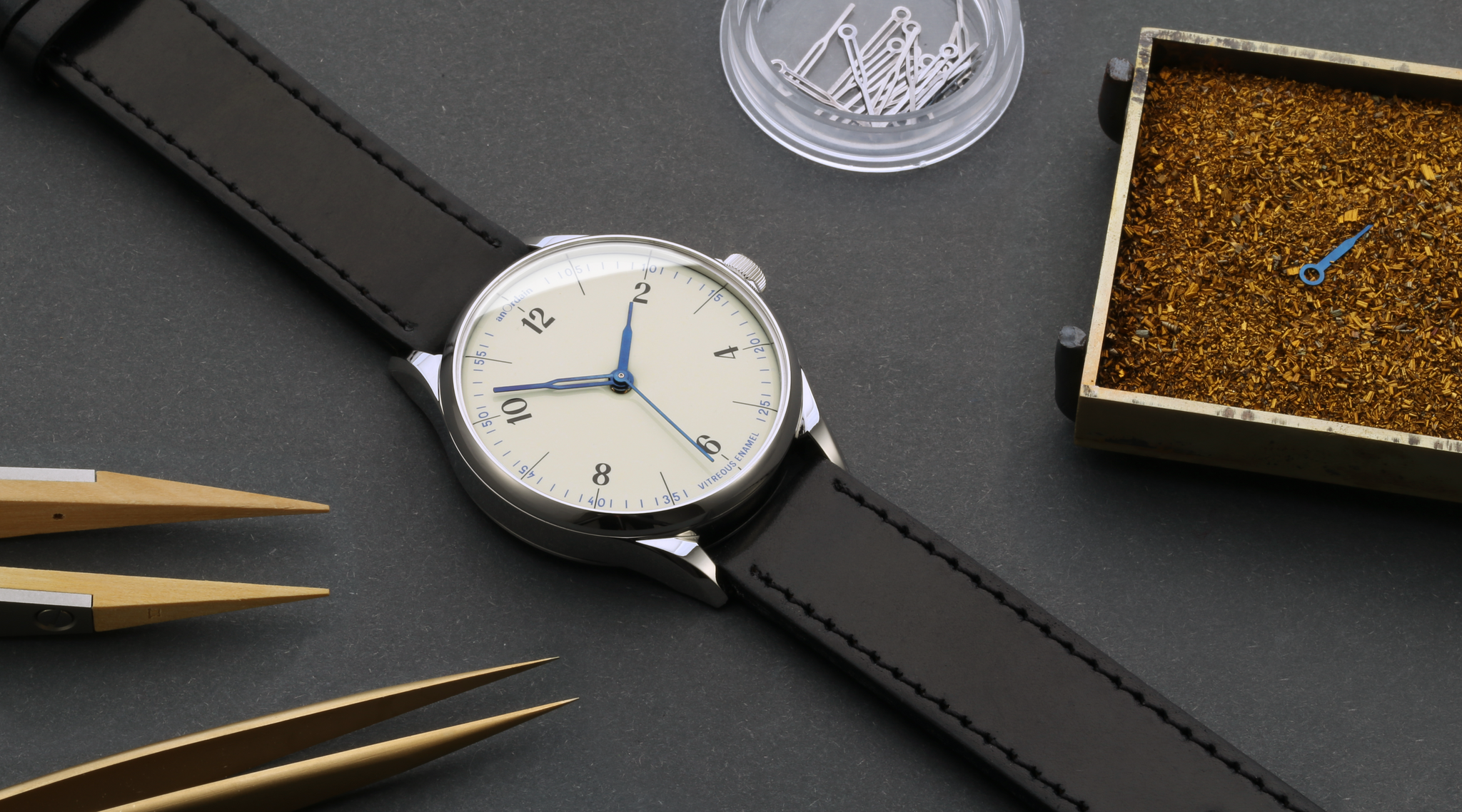 anOrdain Model 1 watch featuring thermally blued steel watch hands lies beside tools used in the heat treatment process