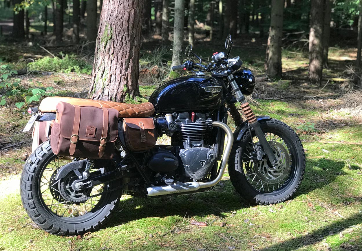 Bonneville with BAAK seat and large brown saddlebag.