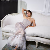 Woman lounging in a silver feathered evening dress
