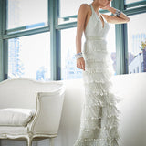 Woman standing near a window in a fringe beaded gown