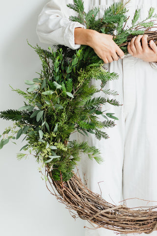 woman in white jumpsuit with wreath