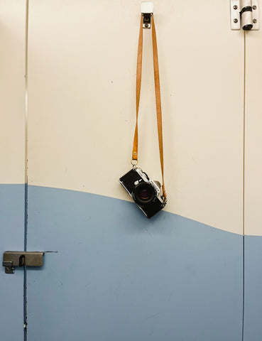 film camera hanging on hook blue paint accidentally wes anderson kelsey schmidt photographer