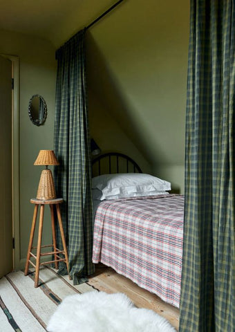 green room with curtains covering small bed