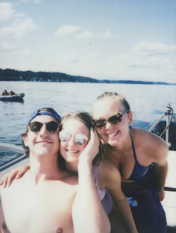 three people smiling on boat