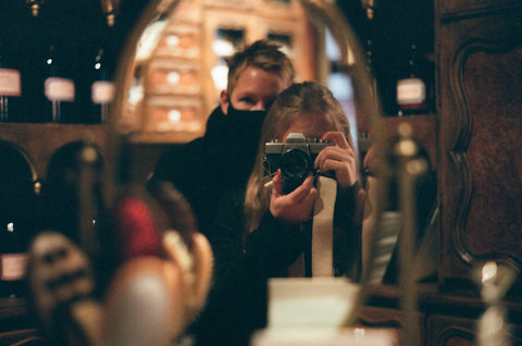 women taking picture in mirror