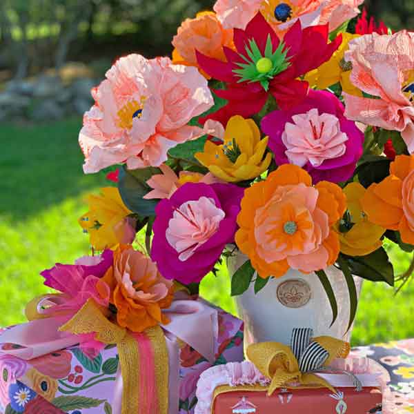 colorful-paper-flowers-in-vase-staged-around-presents-on-table