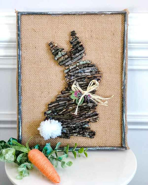 Craft image of Easter rabbit made of sticks on canvas background