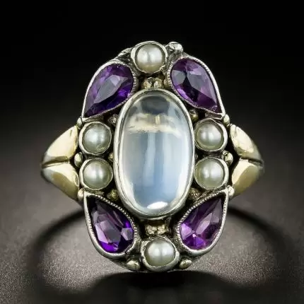 A mixed metal ring featuring a multi-stone design composed of amethyst, moonstone, and pearl; Image: Lang Antiques