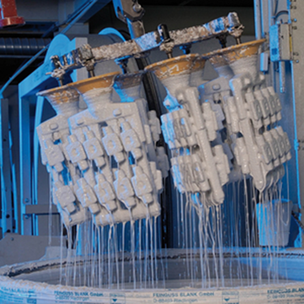 A series of sprued wax models for machine components being dipped into a vat of refractory “slurry” to create a casting shell; Image: Manek Casting