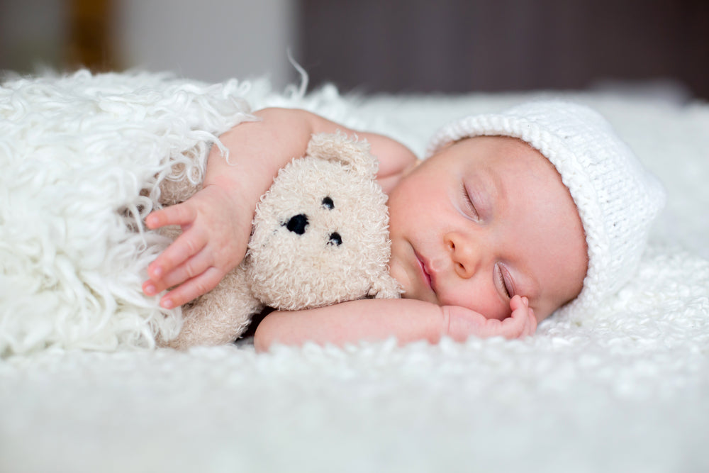 Beautiful newborn baby, sleeping with little toy