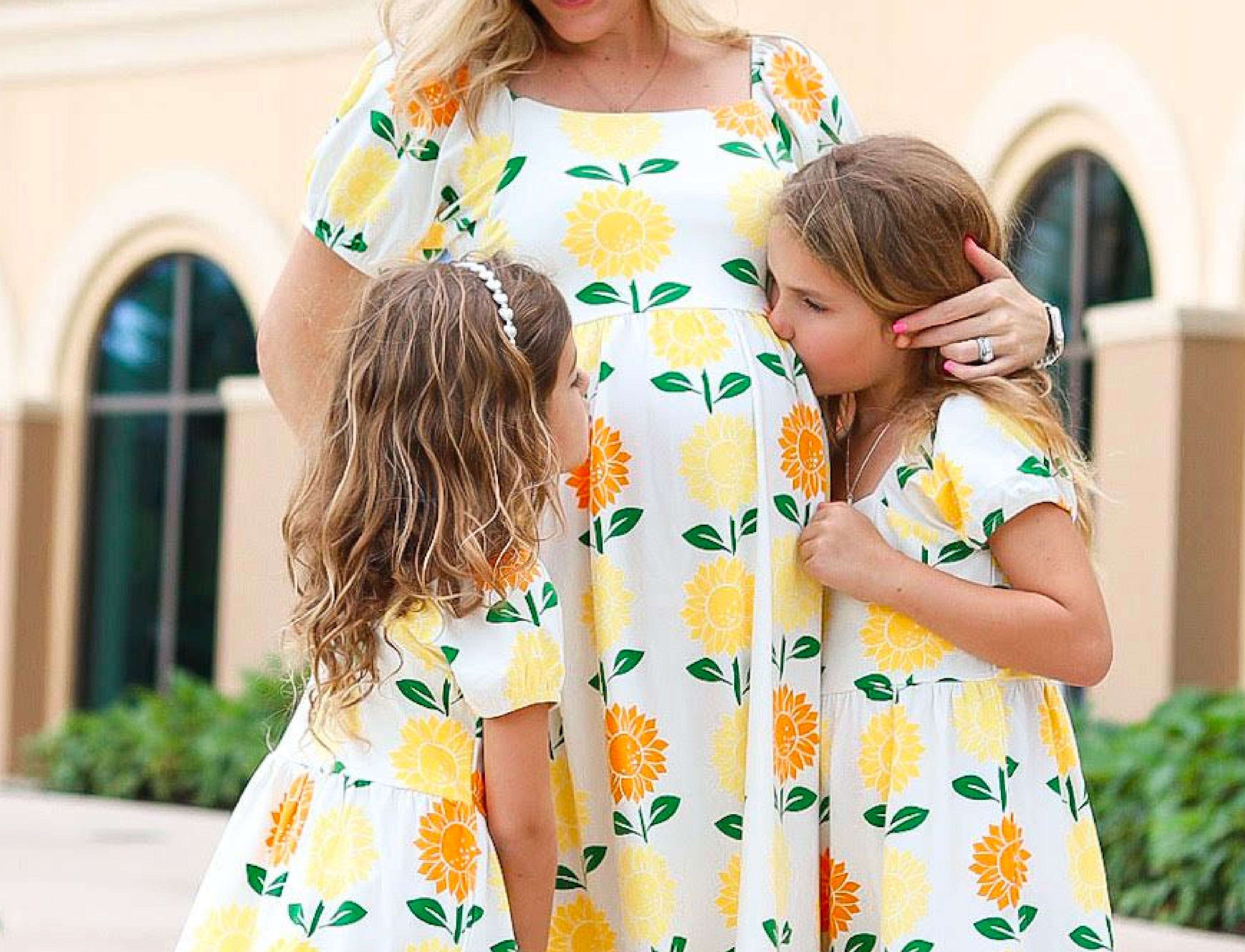 Pregnant mom with daughters in matching dresses