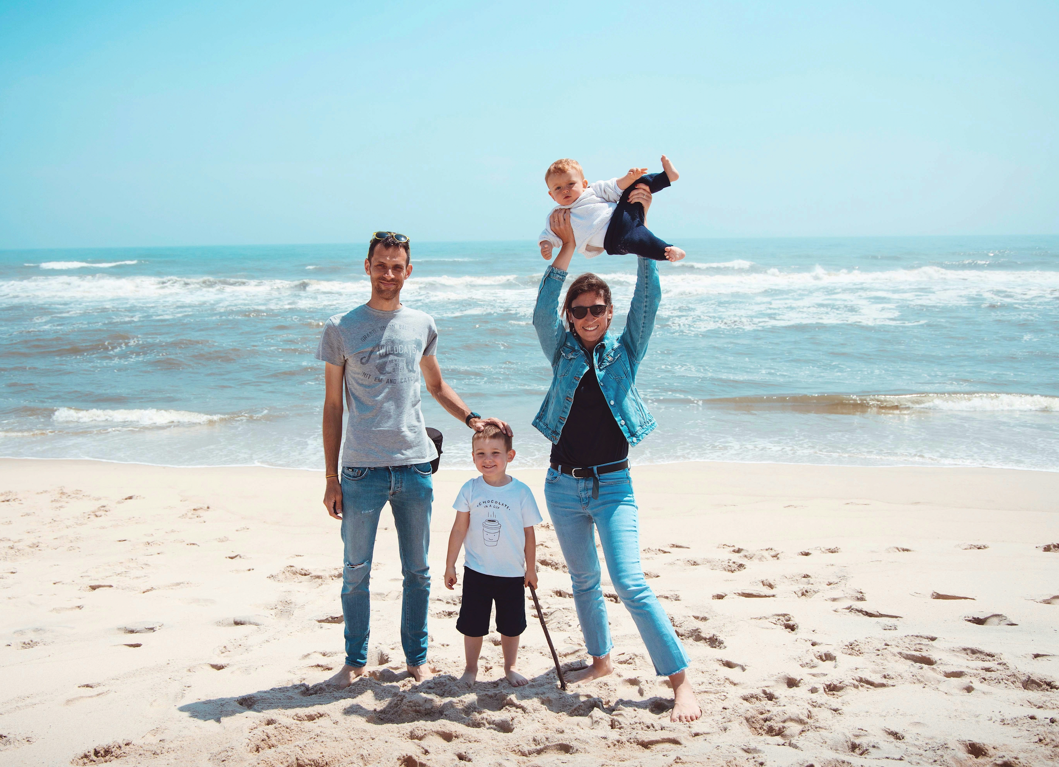 Family standing on ocean beach