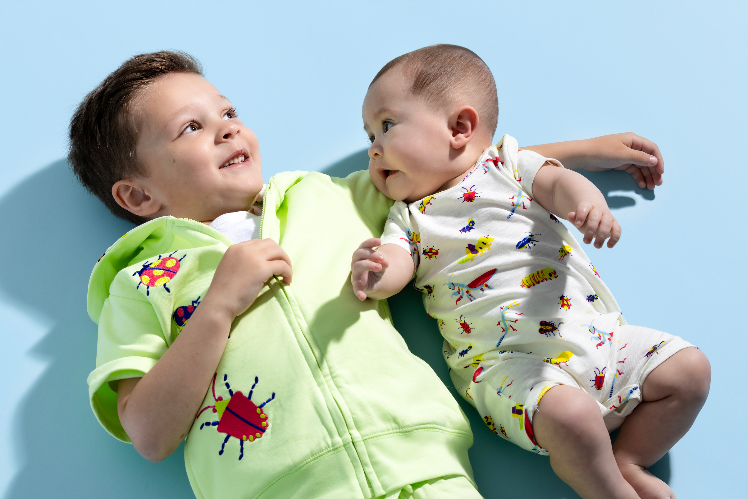 Little boy and baby playing together on the ground