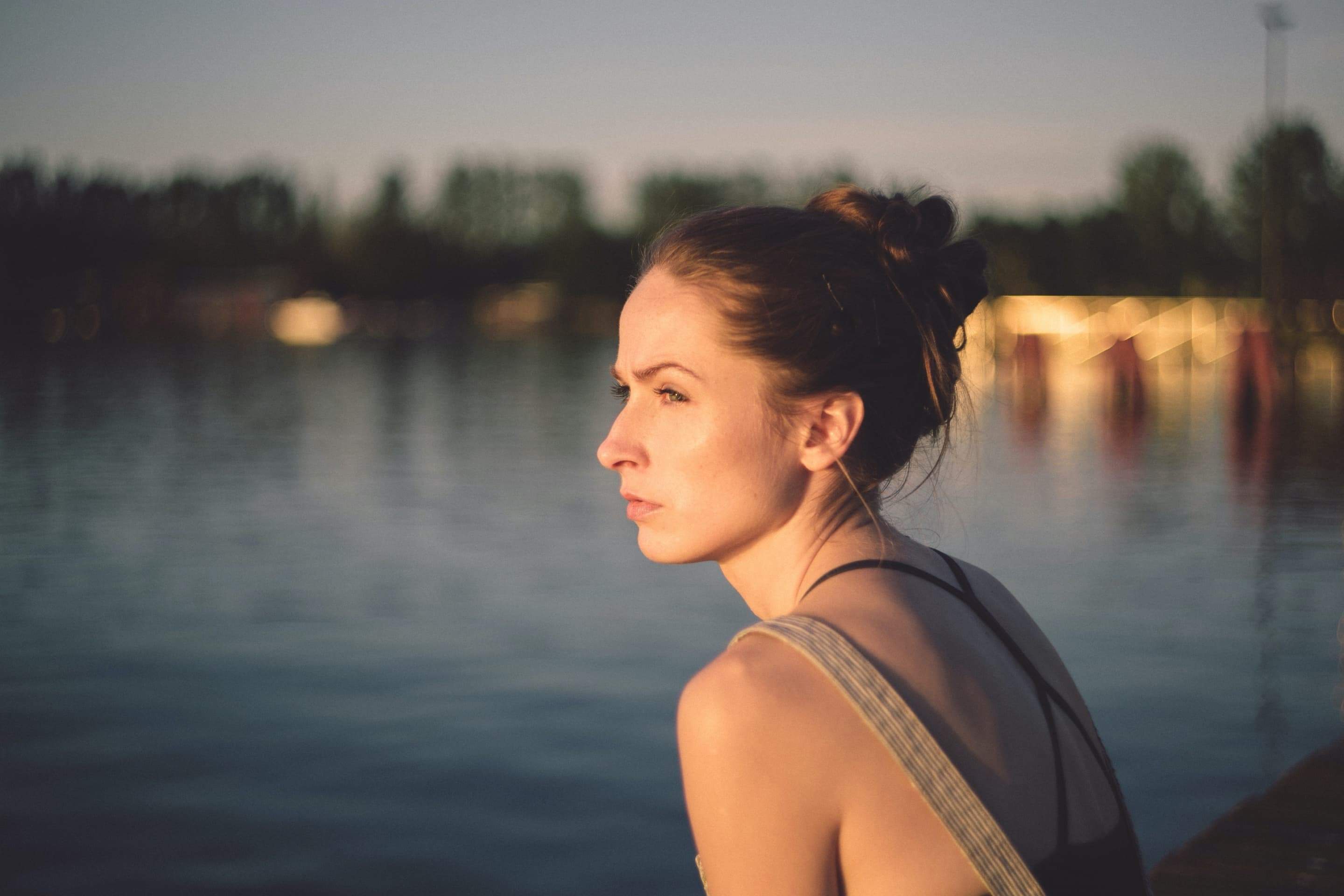 Woman sitting by lake looking out