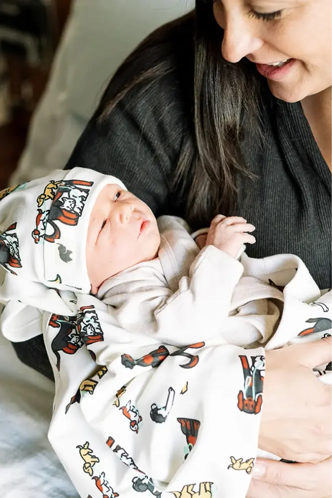 Newborn in animal print onesie + hat