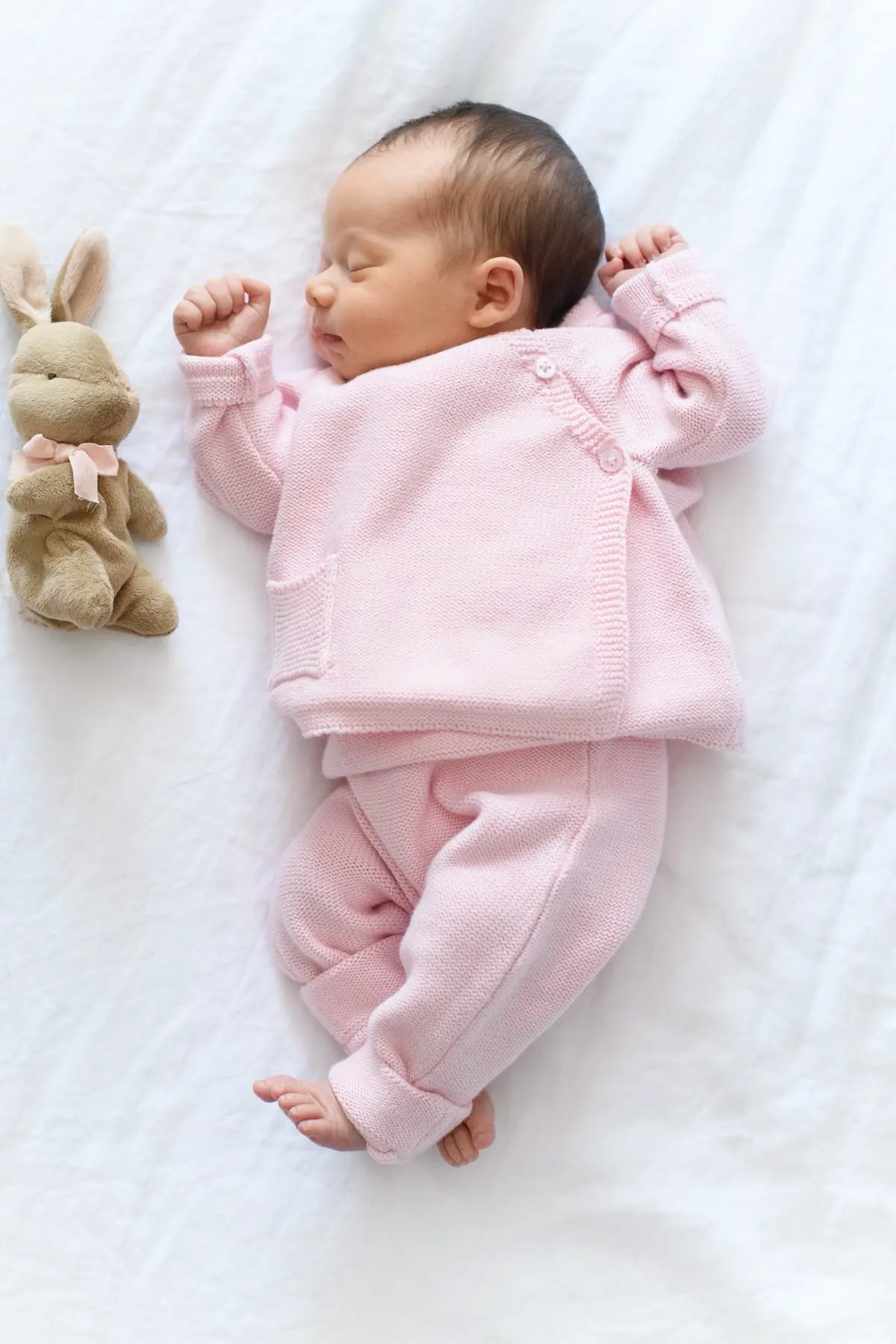 Newborn sleeping in pink romper