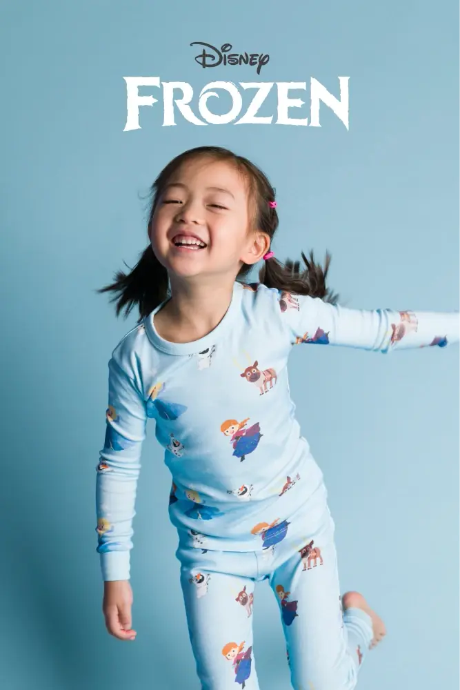 Girls in Disney Frozen print pajamas against blue background