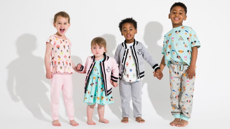 Group of standing kids wearing Disney 100 print clothing