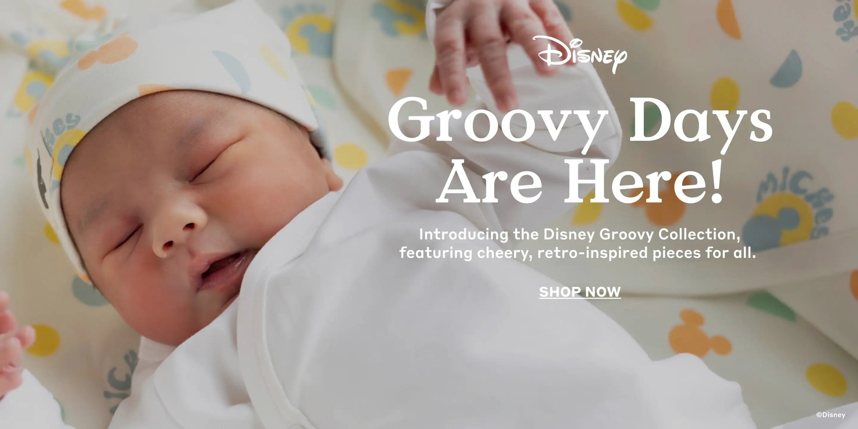 Hero banner with newborn in Disney Groovy print clothing and text: Groovy Days Are Here! Introducing the Disney Groovy Collection, featuring cheery, retro-inspired pieces for all - Shop Now
