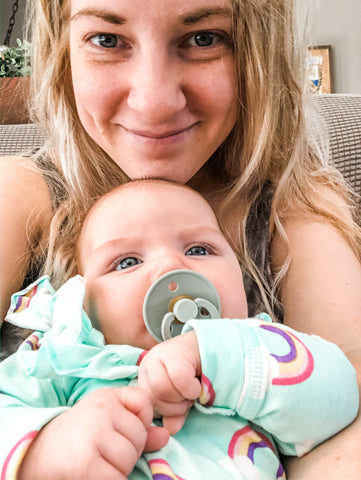 Mom holding baby with pacifier 