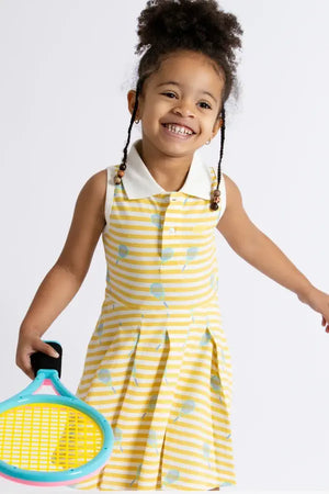Toddler girl in tennis dress holding a tennis racket