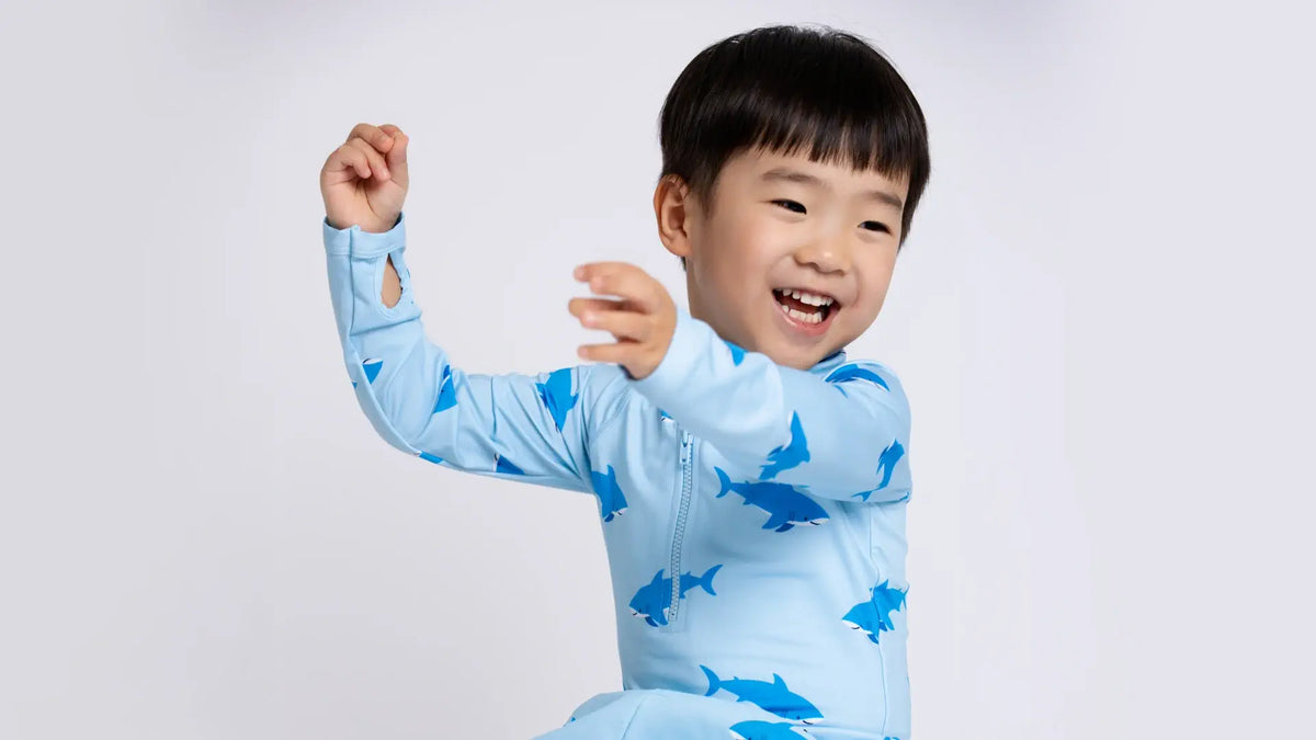 Toddler boy in Swimming Sharks rashguard top
