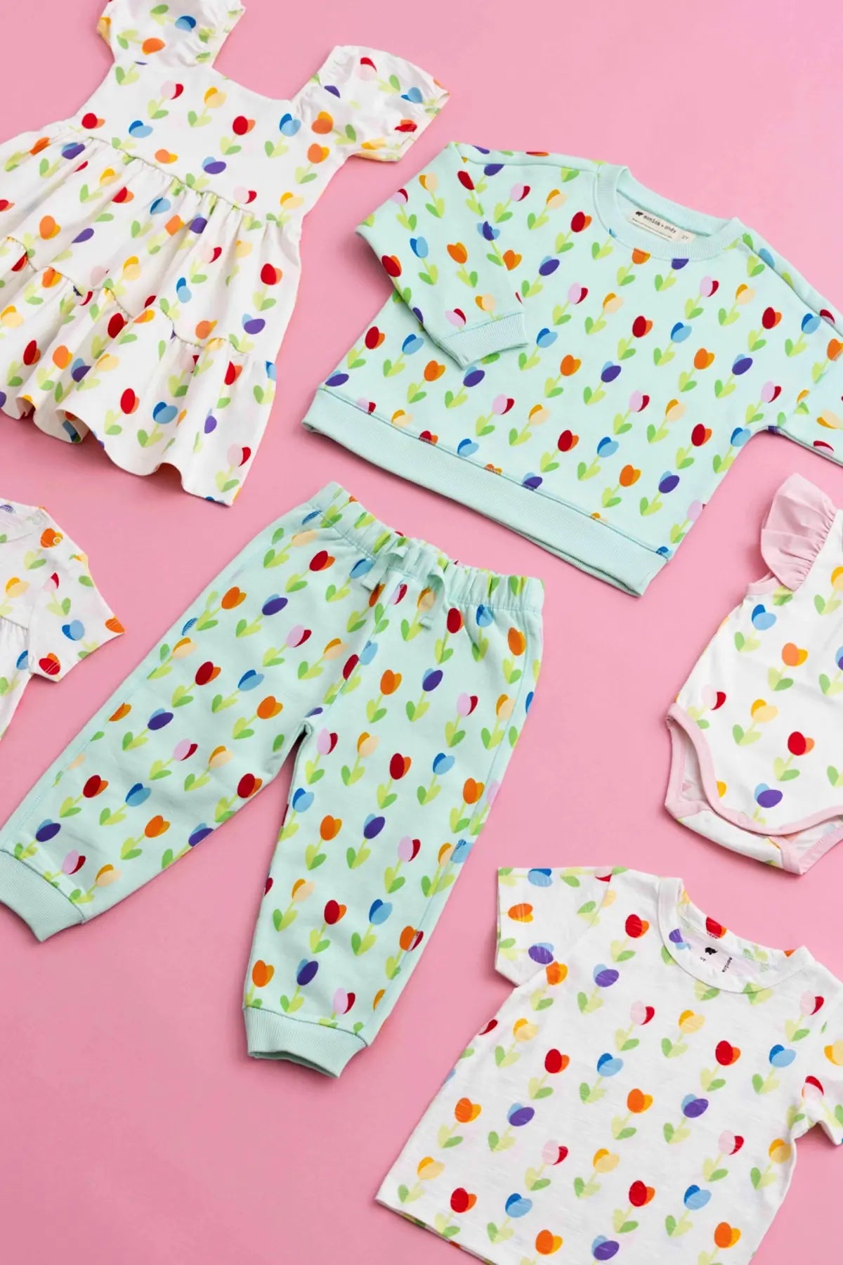 Flatlay of spring print clothing on pink background