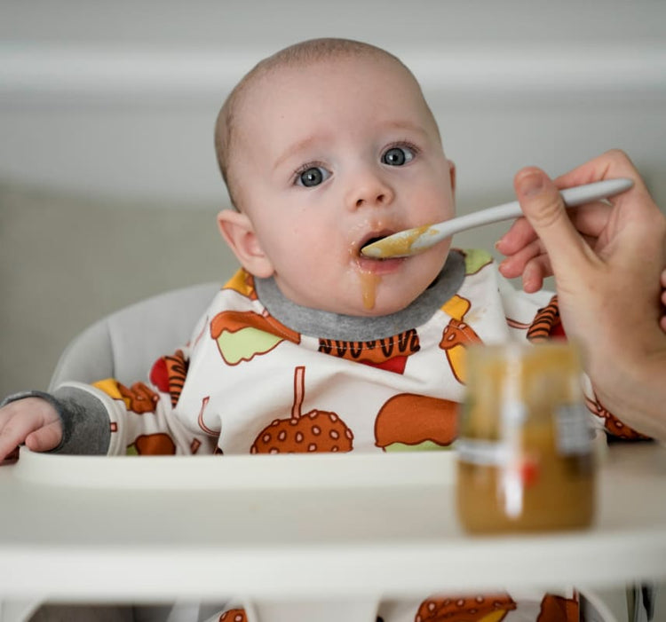 Baby in high chair being fed