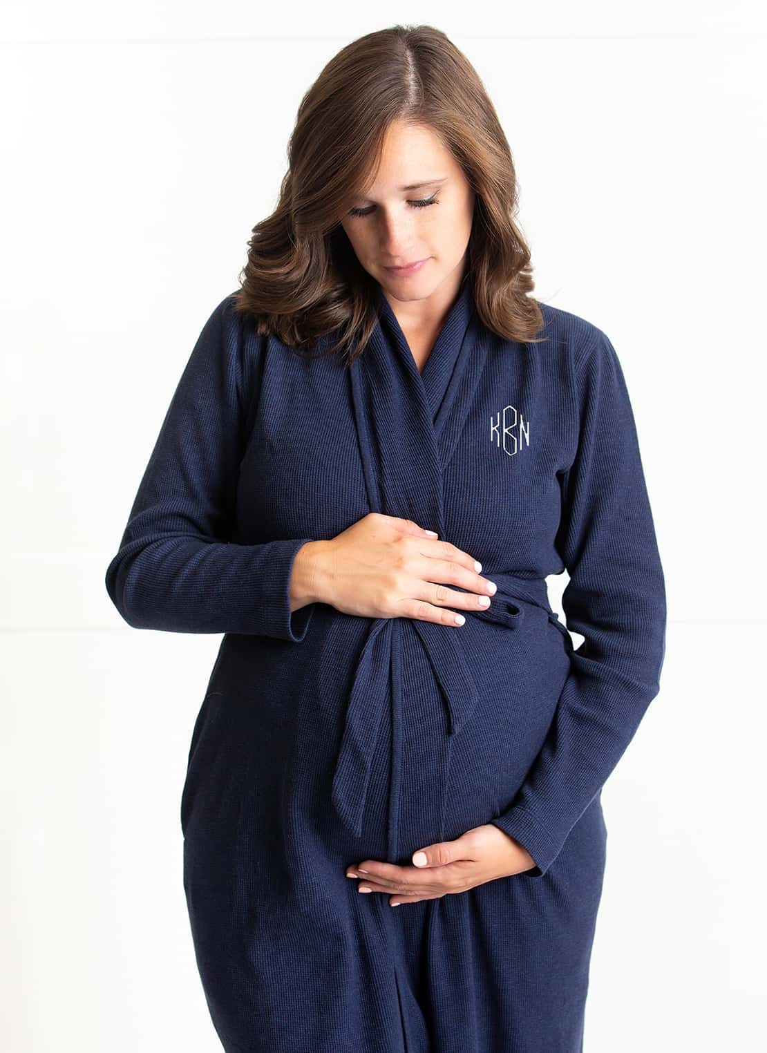 Pregnant woman wearing navy blue monagrammed Organic Lounge Robe