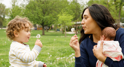 Baby and mom blowing dandelion