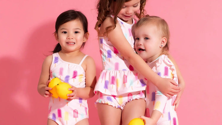 Toddler girls in matching Ice Pop print swimsuits