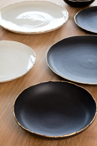 beautiful matte black porcelain handmade dishes with rough edges dripping in gold from personalspacemb.com