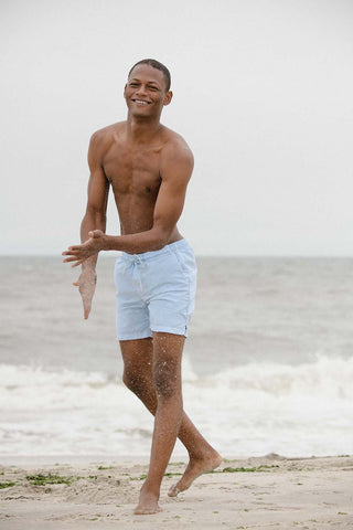 Lucas wearing SKU aqua beach shorts on a beach