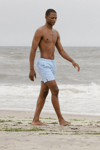 Lucas wearing SKU beach shorts walking on the beach