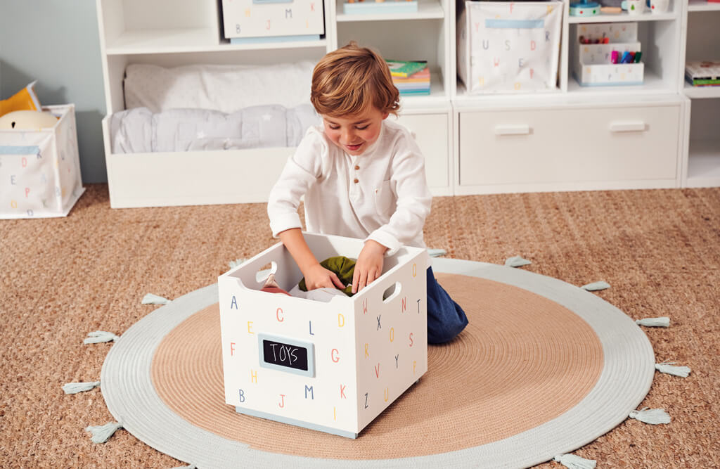 Young boy looking into Alphabet Barbican Toy Box