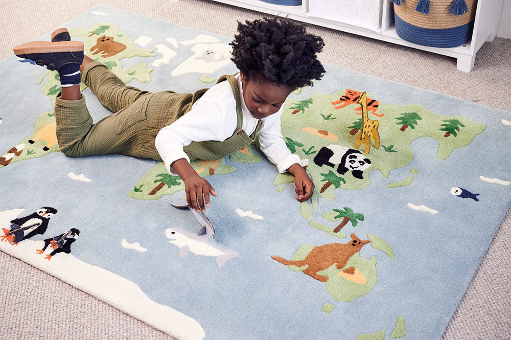 Boy on kids' around the world themed rug