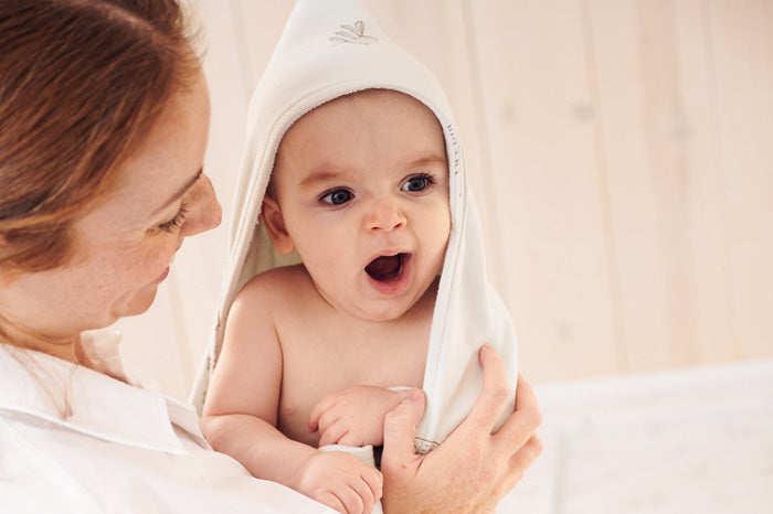 yawning baby wearing hooded towel