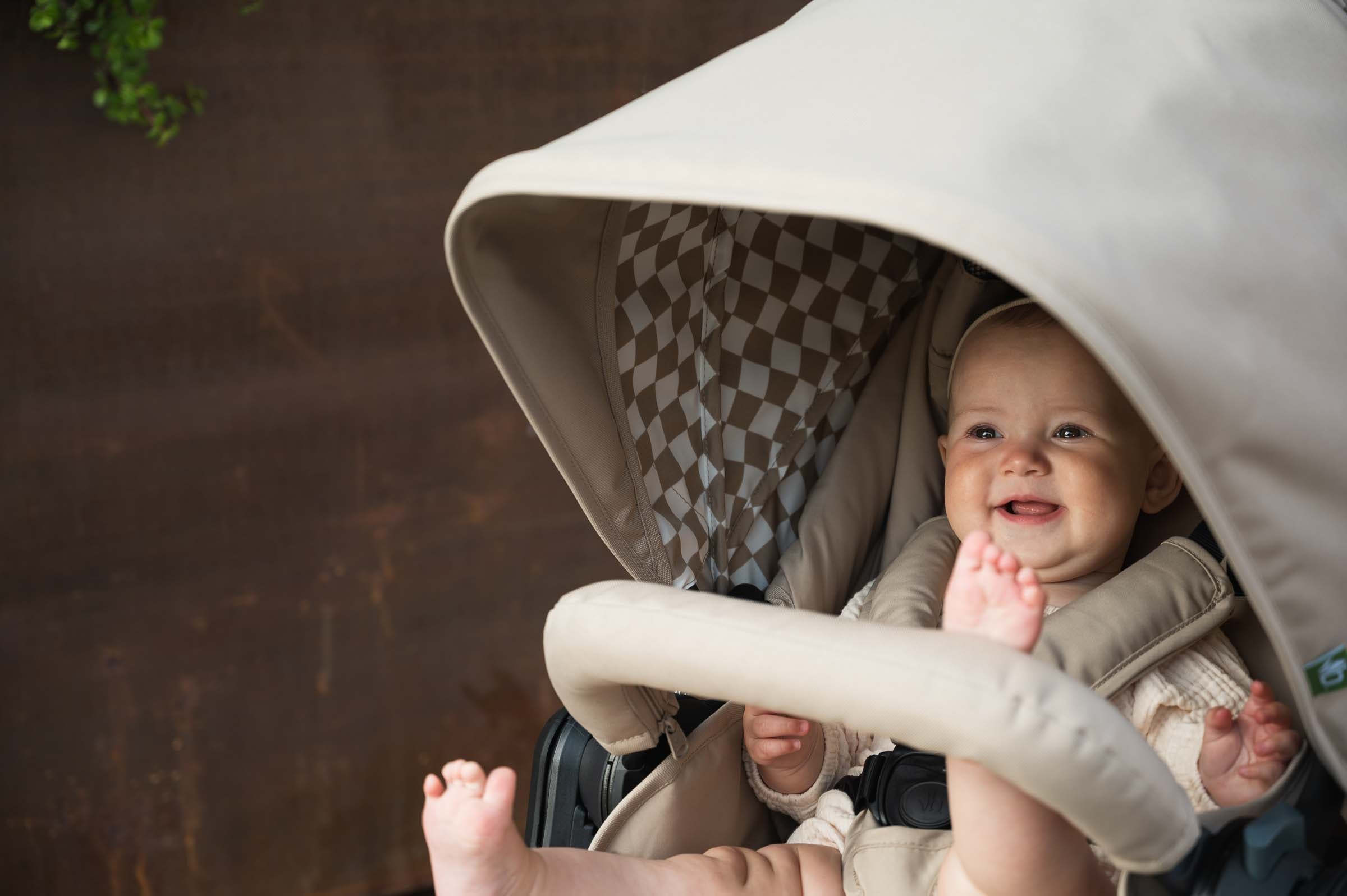 Picture of child smiling inside Bumbleride Era reversible stroller in Sand